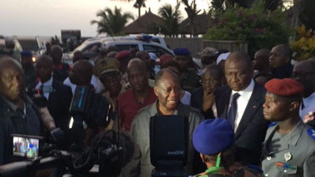 Ivory Coast's President Alassane Ouattara, centre, visits the area were gunmen attacked people in Grand Bassam, on Sunday.