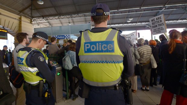 Police watch as protesters rally inside Flinders Street Station on Friday against    Australian Border Force officers taking part in Operation Fortitude.