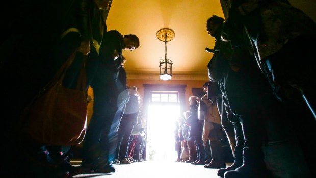 People gather before sunrise at Elizabeth Bay House, lining the hallway ahead of the Winter Solstice.
