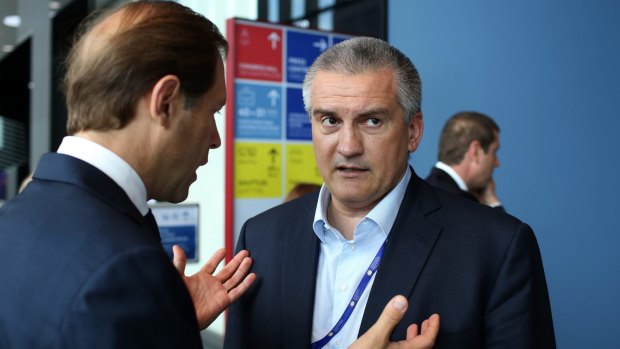 Sergey Aksyonov, "prime minister" of the autonomous republic of Crimea, right, attends the opening day of the St Petersburg International Economic Forum   in June.