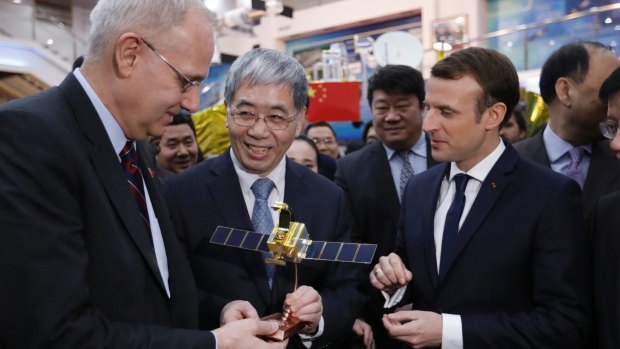 French President Emmanuel Macron, right, and Jean-Yves Le Gall, left, president of the Centre National d'Etudes Spatialesp receive a scale model of the CFOSAT in Beijing.