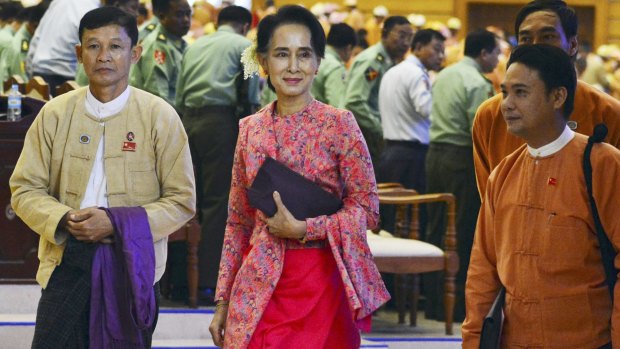 Aung San Suu Kyi, centre, joins National League for Democracy MPs in parliament on Monday.
