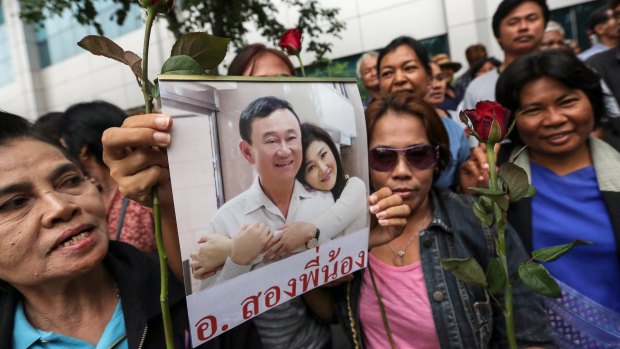 Yingluck Shinawatra's supporters say the charges against her are part of a push by the junta ruling Thailand to marginalise her and her brother, former PM Thaksin Shinawatra (both seen here on a placard).