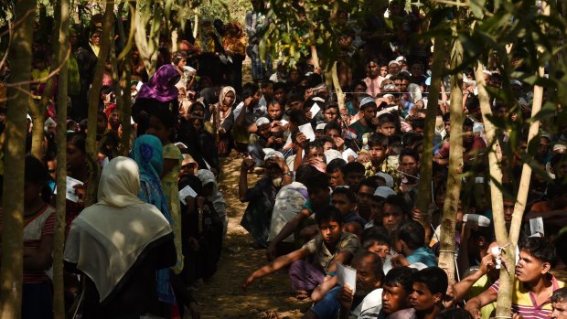 Rohingya refugees line up at a Red Cross distribution point in Burma Para refugee camp, Cox Bazaar, Bangladesh. 