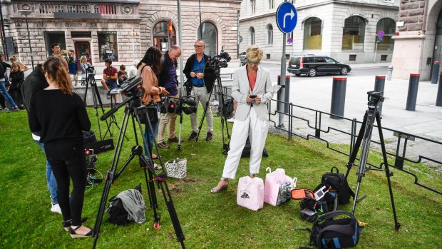 Reporters wait outside Rosenbad, the Swedish government headquarters in Stockholm, after the opposition united to demand no-confidence votes against three cabinet ministers.