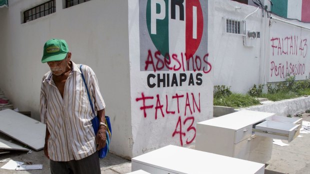 A man walks in front of the Tuxtla Gutierrez office of the Institutional Revolutionary Party (PRI) destroyed by teachers protesting against President Enrique Pena Nieto education reform. 