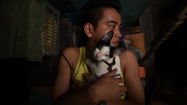 An inmate embraces a kitten as he rests in Quezon city jail. 