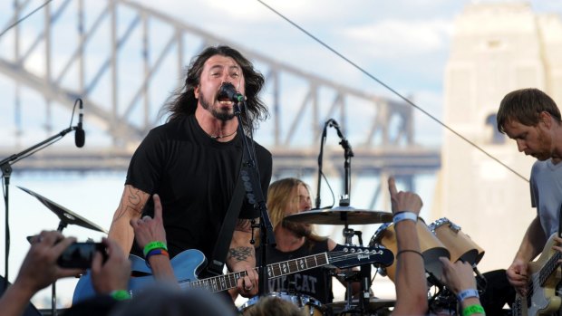 Dave Grohl (left), Taylor Hawkins (back) and Nate Mendel of the Foo Fighters perform on Goat Island in Sydney Harbour in 2011.