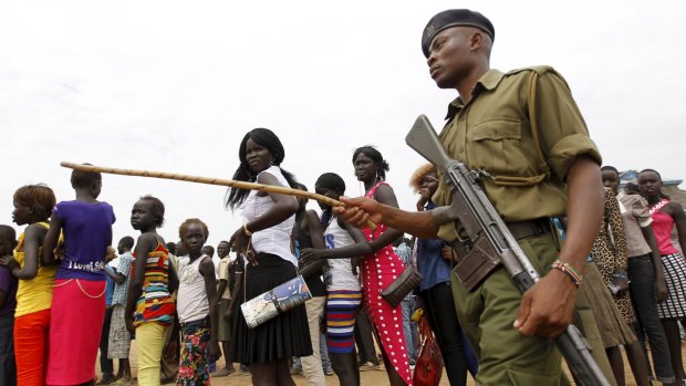 A policeman patrols as refugees from South Sudan queue to attend World Refugee Day celebrations at the Kakuma refugee camp in Kenya.