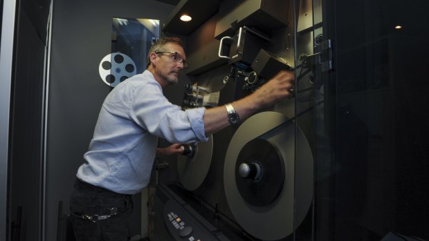 AIATSIS film archivist Tom Eccles operates an aging telecine machine.
