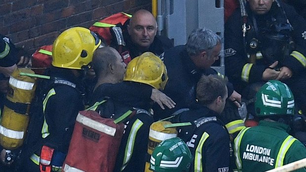 Firefighters rescue a man from the Grenfell Tower fire. 