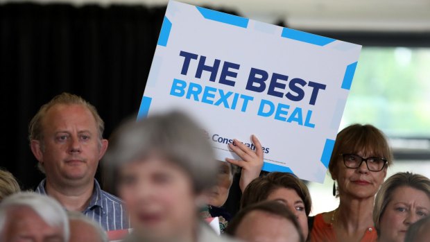An attendee holds a placard behind Theresa May during a campaign event in Twickenham, London, on Monday.