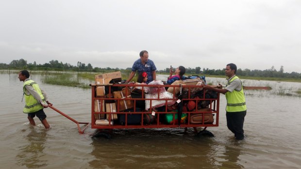 Passengers find their space in a luggage trolley as airport staff maneuver it through Nepal's flooded Janakpur airport in August.