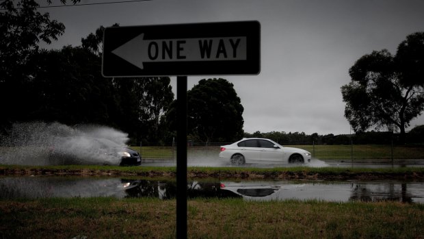Cars driving through flash floods on Burwood Highway on Sunday.