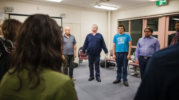 Arts reporter Ron Cerabona, centre, in blue jumper,  joins in with vocal warm-ups at the National Acting School in Dickson. 