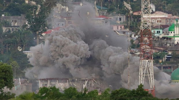 A cloud of debris rises as Philippine Air Force fighter jets bomb suspected locations of Islamist militants in Marawi  on June 9.