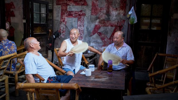 Old men chatting when drinking tea in an old traditional Sichuan teahouse.