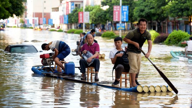People row a bamboo raft in a flooded street in Yongfu, southern China.  