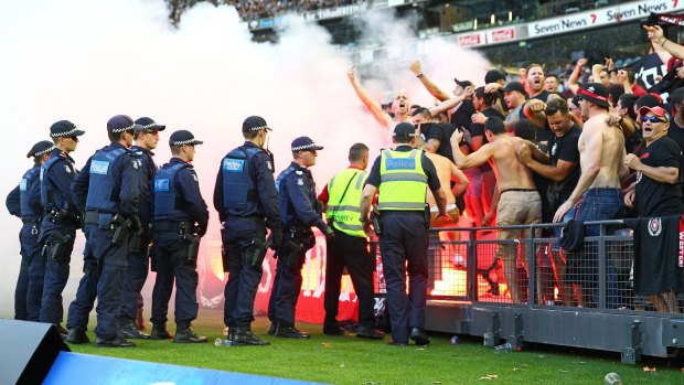 Problematic: Wanderers fans let off flares as police officers look on during the round 18 A-League match against Melbourne Victory at Etihad Stadium earlier this month.