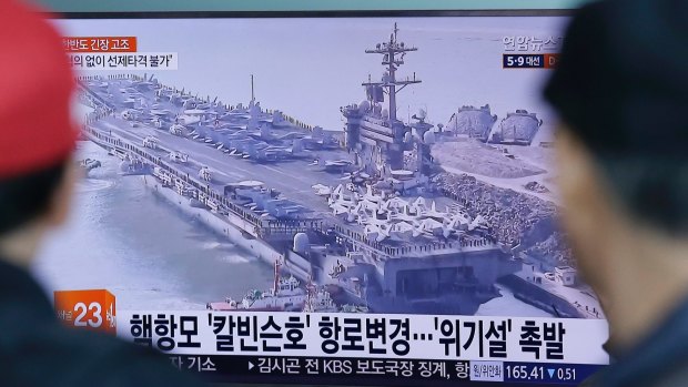 People in Seoul, South Korea, watch a TV news program showing the aircraft carrier USS Carl Vinson on Wednesday.