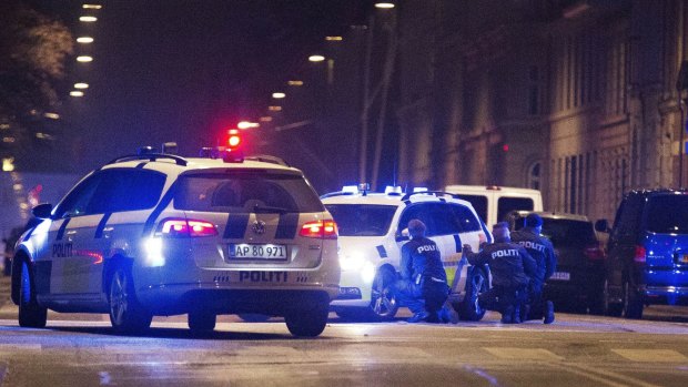 Police take cover in a street in central Copenhagen early on Sunday morning following a fatal shooting at a synagogue in Krystalgade, central Copenhagen.