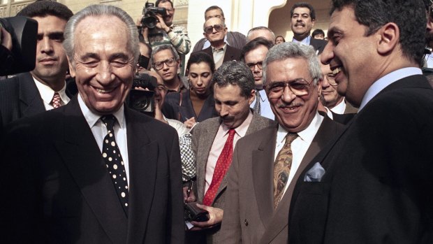 Then: Israeli Foreign Minister Shimon Peres, left, is all smiles along with PLO negotiator Mahmoud Abbas, second from right, in Cairo, in 1993.