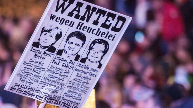 A banner held aloft during a Pegida rally on Monday has images of German leaders under the headline, "Wanted for hypocrisy". 