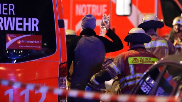Firefighters attend an injured person after a truck ran into crowded Christmas market in Berlin, on Monday.