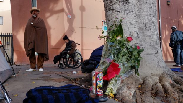 Ceola Waddell, 58, a homeless man who says he witnessed the police shooting on Sunday, stands by a memorial for the victim in downtown Los Angeles.