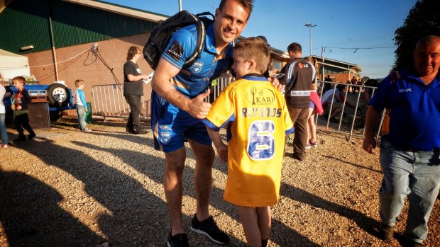 Two sides to the story: Josh Reynolds gives a young fan his City jumper after the game in Wagga Wagga last weekend.