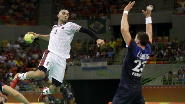 Qatar's Marko Bagaric, from Croatia, left, tries to score past France's Ludovic Fabregas during the men's preliminary handball match between France and Qatar in Rio on Tuesday.