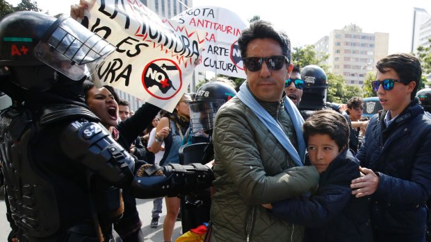 An animal rights activist shouts at people arriving for a bullfight outside the Santamaria bullring in Bogota in January. The protests have resulted in a large police presence.