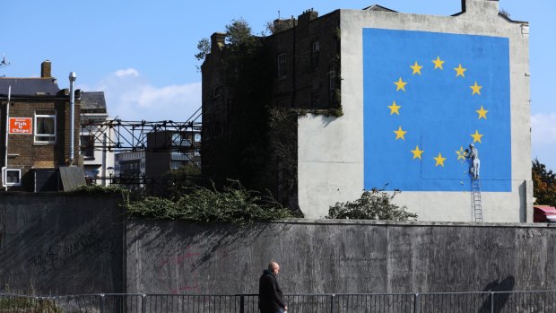 A mural by street artist Banksy depicting a European Union flag being chiseled by a workman covers the side of a building in Dover, UK. 