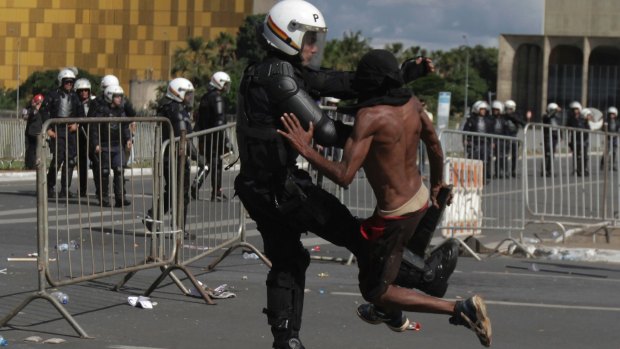 A demonstrator clashes with a police officer during an anti-government protest in Brasilia on Wednesday.