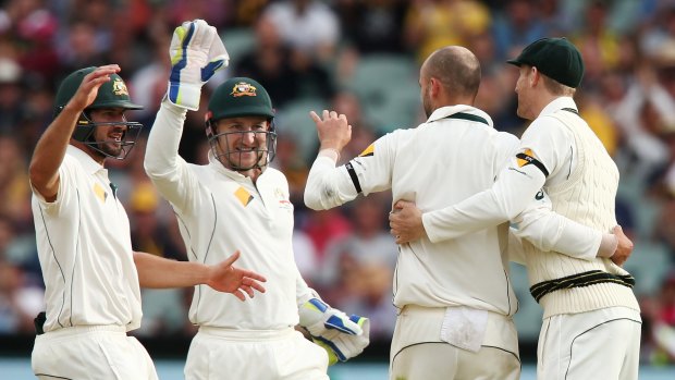 Team first: Joe Burns and Peter Nevill celebrate with Nathan Lyon after he took the wicket of Mark Craig.