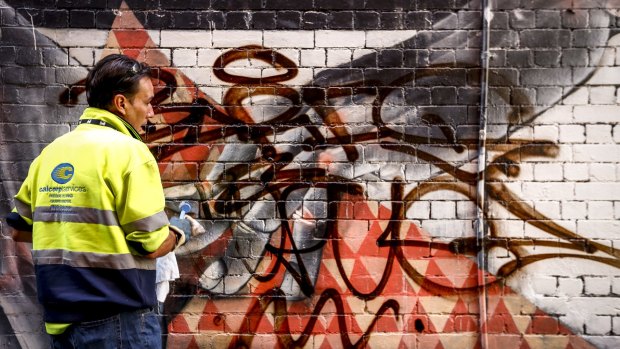 Melbourne City Council graffiti removalist Ben Ivory working in a laneway near Chinatown.