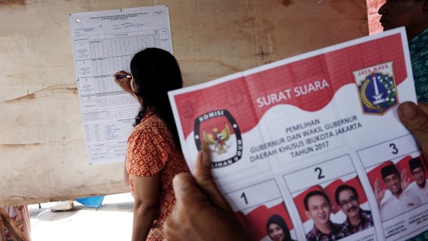 Election workers count ballots at a polling station in Jakarta in February.