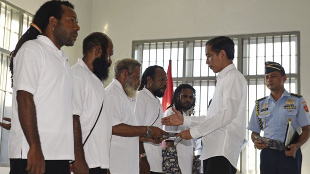 Indonesian President Joko Widodo (right)  hands over the official pardon to five Papuan political prisoners at a prison in Jayapura on May 9. 