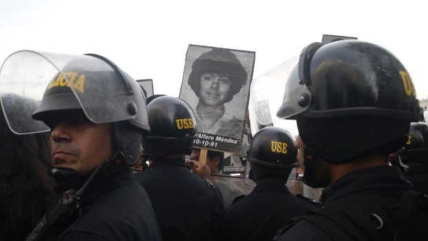 Demonstrators against Fujimori's medical pardon confront riot police in Lima, Peru.