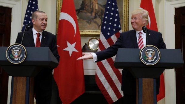 President Donald Trump reaches to shake hands with Turkish President Recep Tayyip Erdogan in Washington on Tuesday.