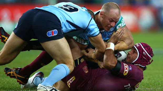 Johnathan Thurston of the Maroons is tackled by Beau Scott of the Blues and Robbie Farah of the Blues during game one of the State of Origin.