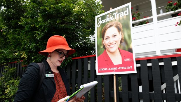 Greens candidate for South Brisbane Amy MacMahon walks past a corflute of Deputy Queensland Premier Jackie Trad while doorknocking in the electorate of South Brisbane.