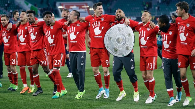 Bayern's Arturo Vidal carries a mock trophy as he and his teammates celebrate winning the title.