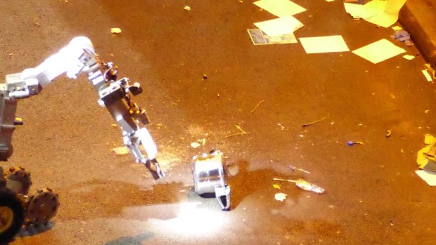 A New York Police Department bomb disposal robot handles an unexploded pressure cooker bomb on West 27th Street in New York City on Saturday.