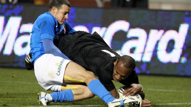 Italy's Kaine Robertson tackles All Blacks winger Joe Rokocoko in Christchurch in 2009.