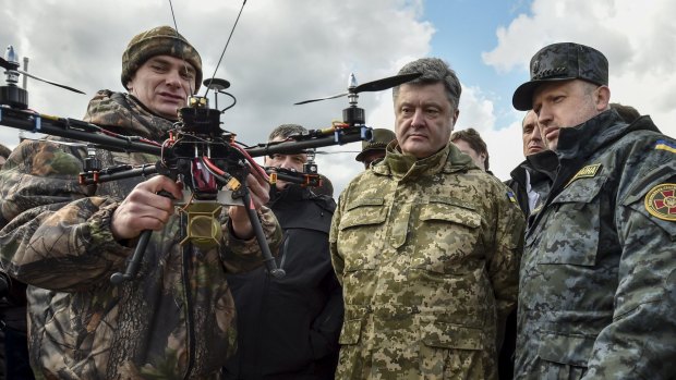 Ukraine's President Petro Poroshenko (centre) and the Ukrainian secretary to the National Security and Defence Council Oleksandr Turchynov (right) inspect weapons and military equipment at the Ukrainian National Guard training centre outside Kiev.