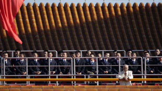 Security officers sit on the Tiananmen Gate, ahead of the military parade.