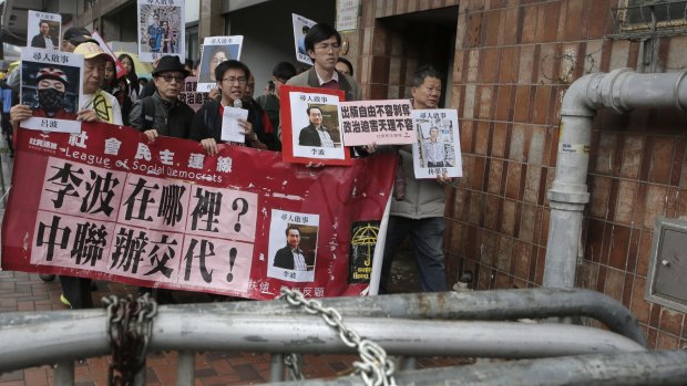 Protesters hold photos of missing booksellers during a protest in Hong Kong on Sunday.