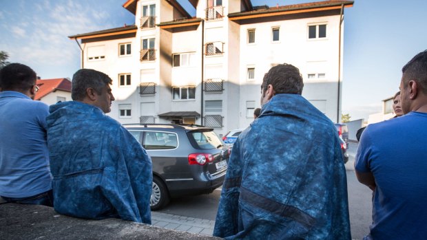 Residents sit in front of an accommodation for asylum seekers in Heppenheim, Germany.