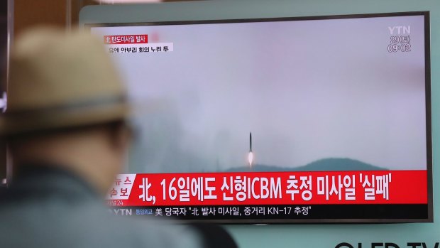 A man watches a TV news program reporting a North Korean missile test.